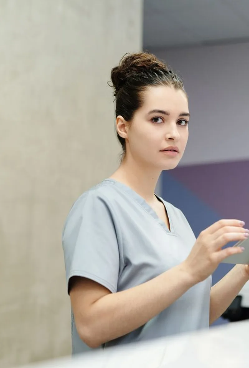 Secrétaire en blouse consultant l’agenda du cabinet sur une tablette